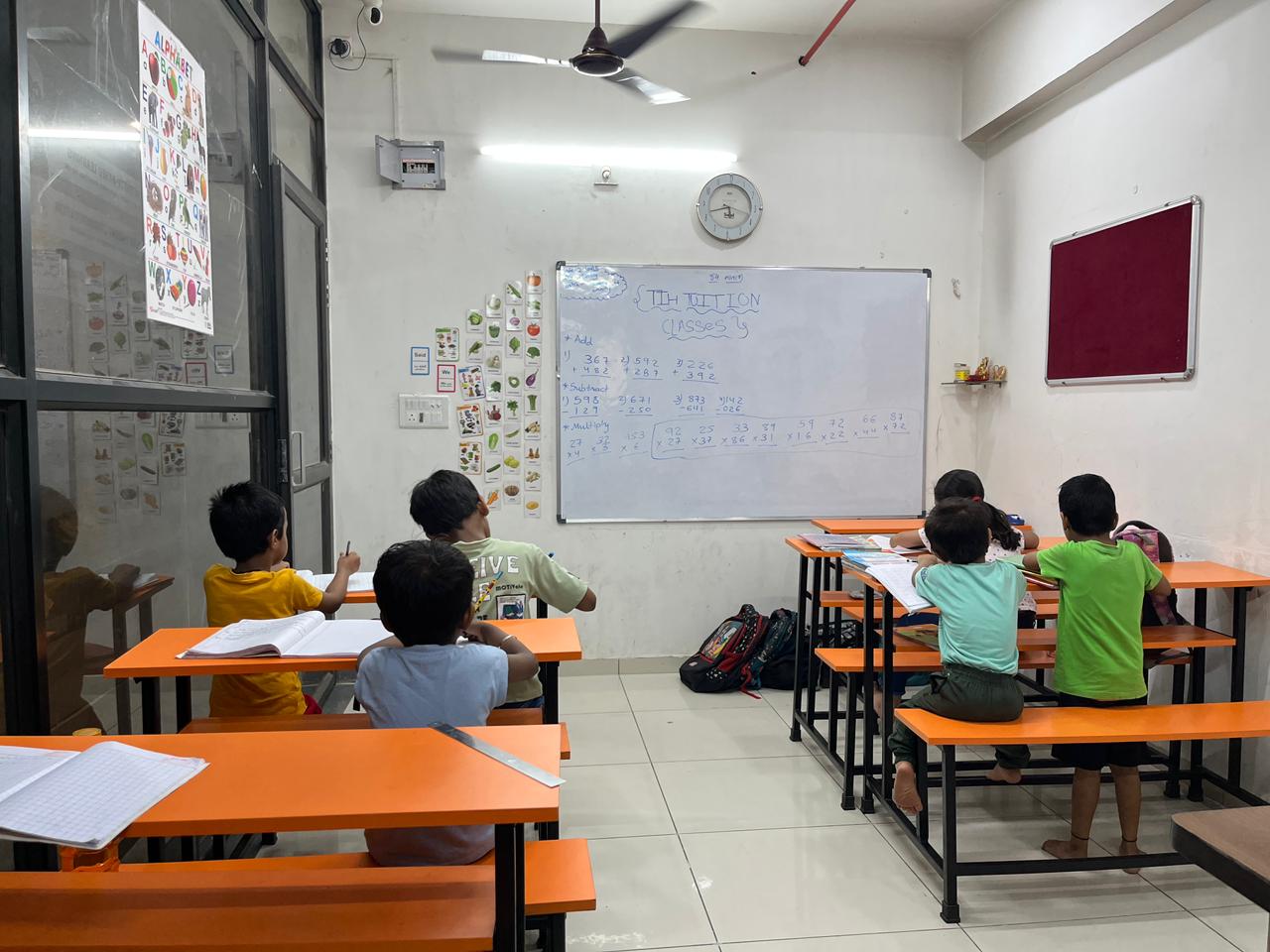Children attending maths tuition class in a modern classroom with whiteboard teaching
